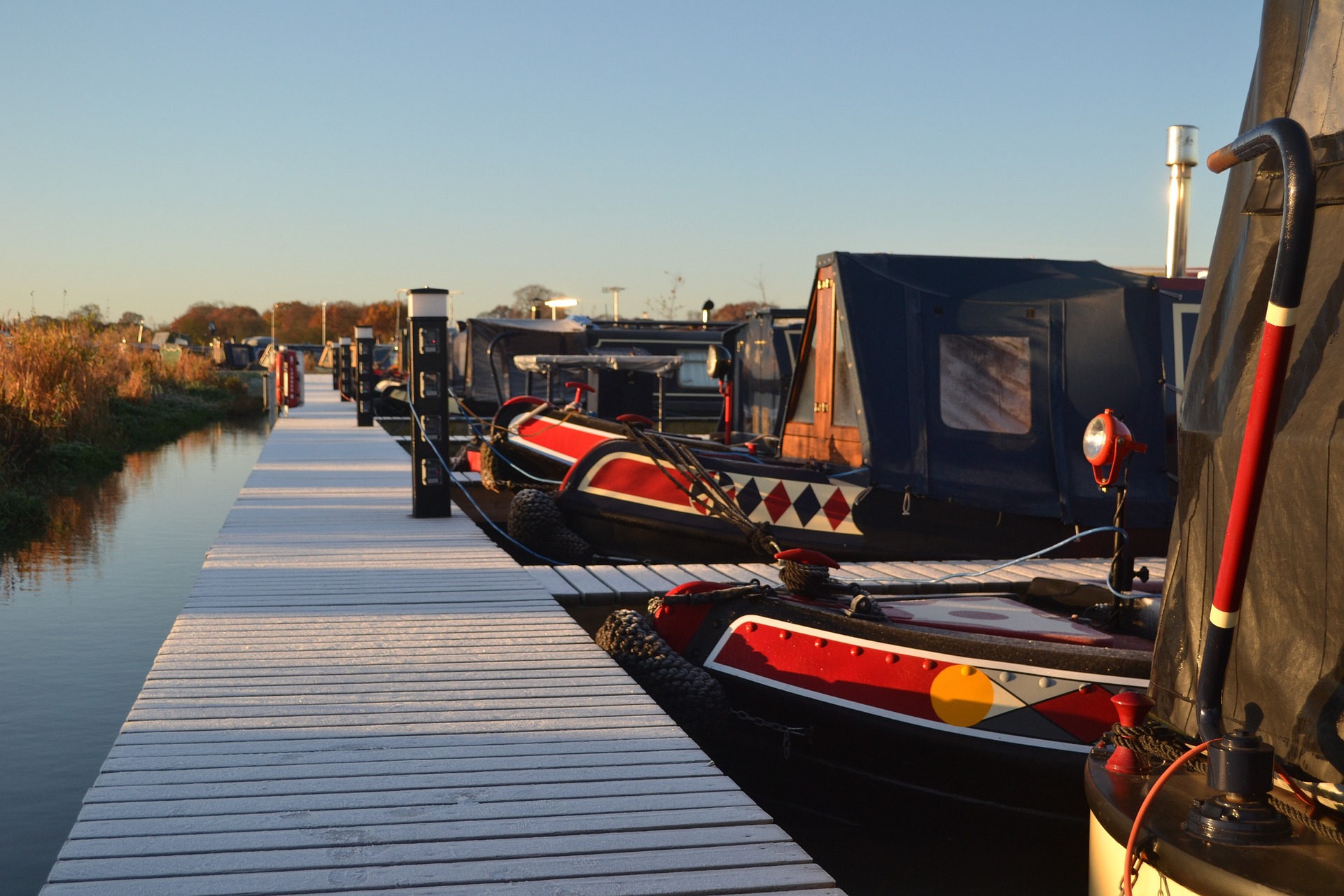 A row of narrowboats moored up for the evening. Brecknock Boat Services
